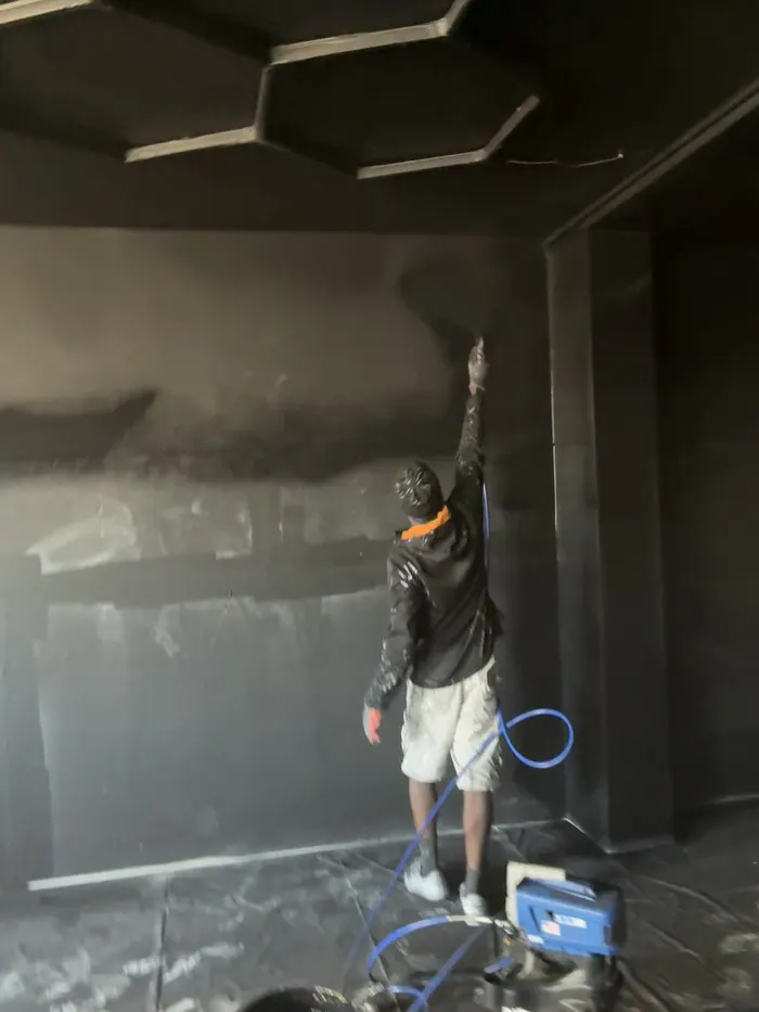 Application de peinture au pistolet sur les murs d’un local
